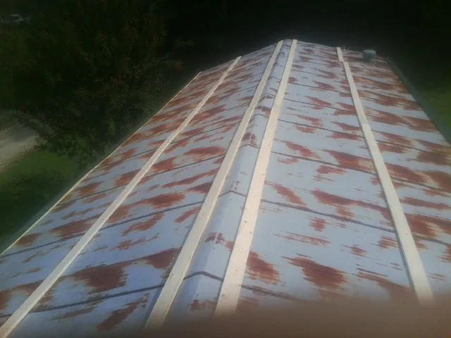 Rusted metal roof panels with new wood purlins before replacement — Storm Damage Roof Repair in Woodman by Roofing Brothers